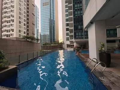 a swimming pool in the middle of a building with tall buildings at Aesthetic Modern Suite 1BR One Uptown Residence BGC in Manila
