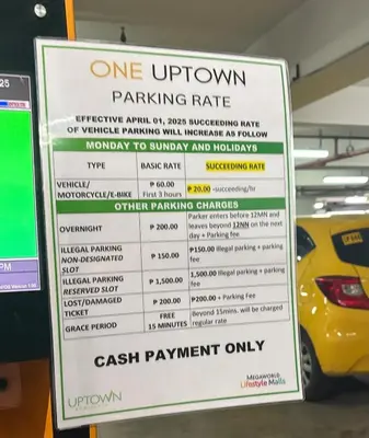 a parking rate sign in a parking garage at Aesthetic Modern Suite 1BR One Uptown Residence BGC in Manila