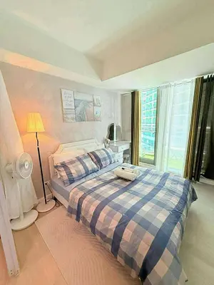 a bedroom with a bed and a lamp and a window at Condotels Villa Topaz in Manila