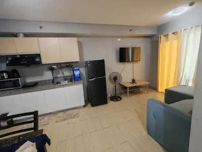 a kitchen and living room with a refrigerator and a couch at Condotels Villa Topaz in Manila