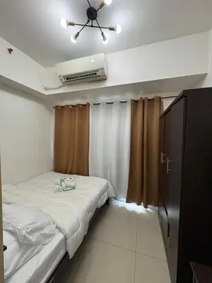 a small bedroom with a bed and a ceiling fan at Jazz Residences in Manila