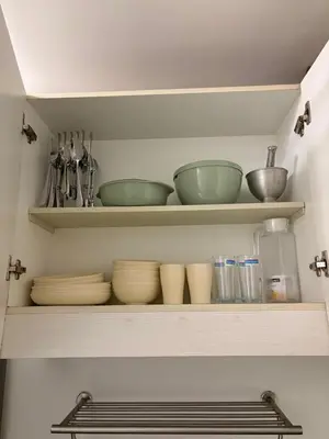a shelf with bowls and other kitchen utensils at Jazz Residences in Manila