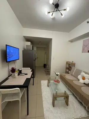 a living room with a couch and a table at Jazz Residences in Manila