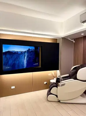 a living room with a flat screen tv on a wall at 29H Ultimate Esports Studio Massage Chair Pro Setup in Manila