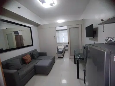 a living room with a couch and a table at Sea Residences MOA Area in Pasay City in Manila