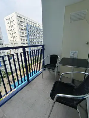 a balcony with two chairs and a table on a building at Sea Residences MOA Area in Pasay City in Manila