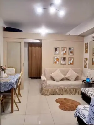 a living room with a couch and a table at Sea Residences MOA Area in Pasay City in Manila