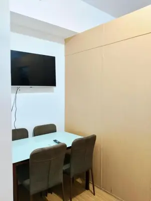 a dining room with a table and chairs and a tv at Penguin Hotel in Manila