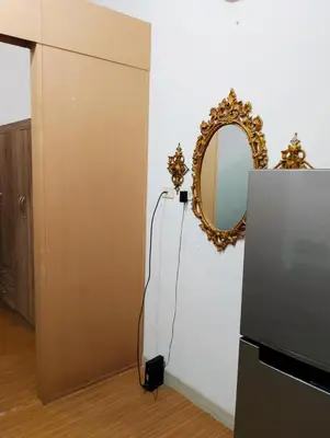 a mirror on a wall next to a refrigerator at Penguin Hotel in Manila