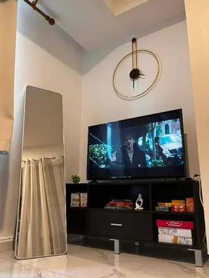 a living room with a flat screen tv on a tv stand at Zyron Suite in Manila