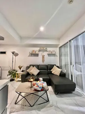 a living room with a black couch and a table at Zyron Suite in Manila