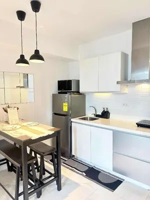 a kitchen with a table and a stainless steel refrigerator at Zyron Suite in Manila