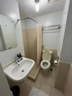 a bathroom with a sink and a toilet and a mirror at Antel Spa Residences 1710 in Manila