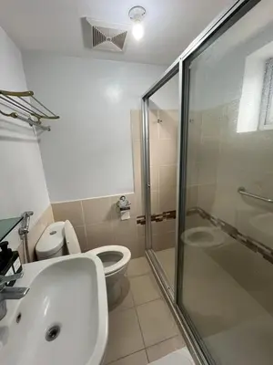 a bathroom with a toilet and a sink and a shower at Antel Spa Residences 1710 in Manila