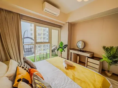 a bedroom with a bed and a large window at Spacious & Luxury 4BR Home across Okada and Solaire in Manila
