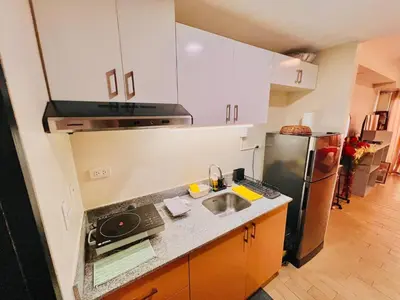 a kitchen with a sink and a refrigerator at Cozy BB in the Heart of Quezon City in Manila