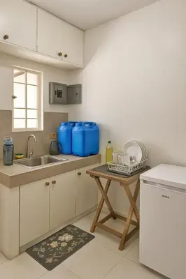 a white kitchen with a sink and a table at Islana Stay for Family of 3 in Gen Trias Cavite in General Trias
