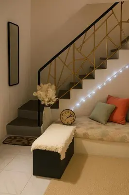 a living room with a bed under a staircase at Islana Stay for Family of 3 in Gen Trias Cavite in General Trias