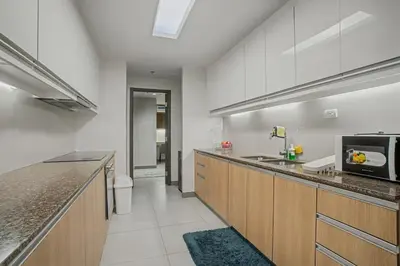 a kitchen with wooden cabinets and a microwave at Elegant and Spacious 3BR Home near Okada, Solaire in Manila