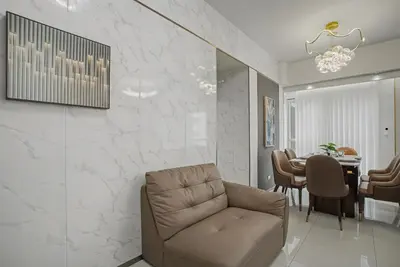 a living room with a chair and a table at Modern and Spacious 3BR Home near Solaire & Okada in Manila