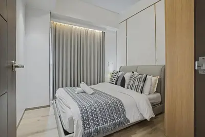 a bedroom with a bed and a large window at Modern and Spacious 3BR Home near Solaire & Okada in Manila