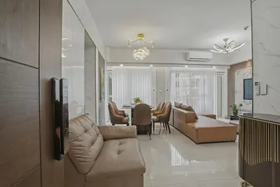 a living room with a couch and a dining room at Modern and Spacious 3BR Home near Solaire & Okada in Manila