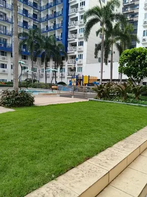 a park with a playground and palm trees at Rosaland staycation in Manila