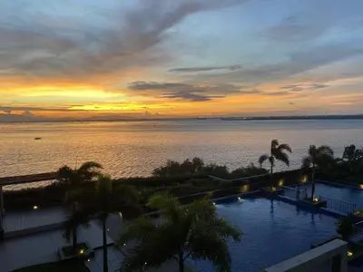 a sunset over the water with a swimming pool at 120SQM 3Bedrooms with Balcony Facing Infinity Pool Manila Bay Sunset, Near Airports, OKADA, Solaire, MOA with Free Parking in Manila