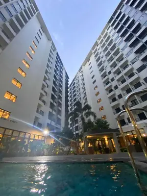 two tall buildings with a pool in front of them at Metro Home Staycation in Manila