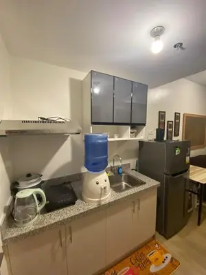 a small kitchen with a sink and a refrigerator at Metro Home Staycation in Manila