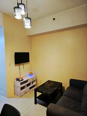 a living room with a couch and a tv at Nest & Rest by RanDecz in Manila