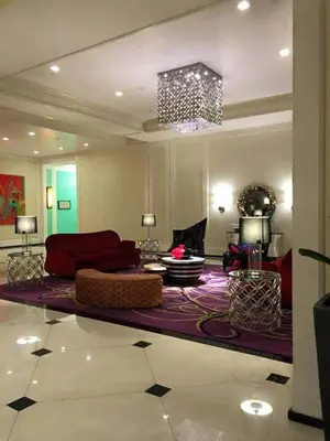 a living room with a red couch and a rug at Stamford Executive Residences, McKinley Hill in Manila