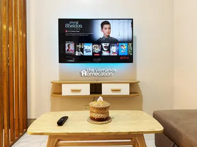 a living room with a tv and a coffee table at Cozy Modern Condo in Little Baguio Terraces San Juan City in Manila