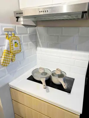 a stove top with two pans on top of it at Cozy Modern Condo in Little Baguio Terraces San Juan City in Manila