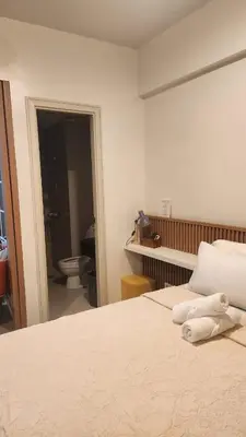a bedroom with a bed and a bathroom with a toilet at Your Home Suite at 150 Newport Boulevard Condo near NAIA T3 in Manila