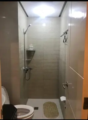 a small bathroom with a shower with a toilet at Your Home Suite at 150 Newport Boulevard Condo near NAIA T3 in Manila