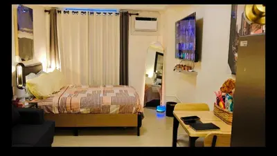 a bedroom with a bed and a living room at Kasara Urban Resort premium studio staycation by Rain in Manila