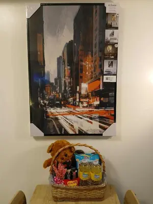 a basket on a table with a picture of a city at Kasara Urban Resort premium studio staycation by Rain in Manila