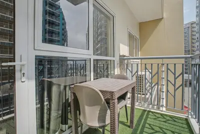 a balcony with a table and chairs on a balcony at Lovely & Spacious 2BR Home near Solaire & Okada in Manila
