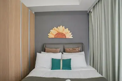 a bedroom with a bed with a flower above it at Lovely & Spacious 2BR Home near Solaire & Okada in Manila