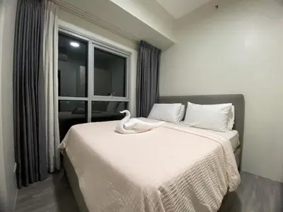 a bedroom with a white bed with a swan on it at 120 Sqm Modern 3Bedrooms HighRise Facing Manila Bay, Near Airports, Okada Casino, Solaire Casino, MOA with free parking in Manila