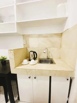 a small kitchen with a sink in a room at Makati Avenue Suites in Manila