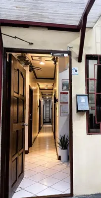 a hallway with an open door and a hallway with a plant at Makati Avenue Suites in Manila