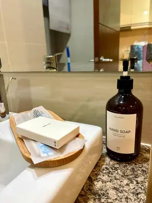 a bottle of hand soap sitting on a bathroom sink at Japandi Haven with Uptown Mall Fountain View One Uptown BGC in Manila