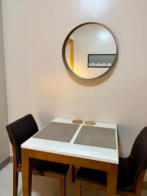 a table with a mirror and a table with chairs at Japandi Haven with Uptown Mall Fountain View One Uptown BGC in Manila