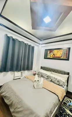 a bedroom with a large bed with a ceiling at City Condo Perfect for Family & Friends in Manila