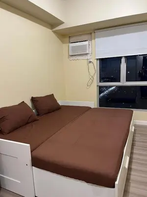 a bedroom with a bed and a window at Staycation Condotels RD in Manila