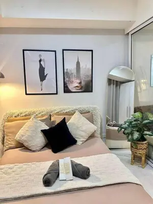 a bedroom with a large bed with pictures on the wall at Staycation Condotels RD in Manila