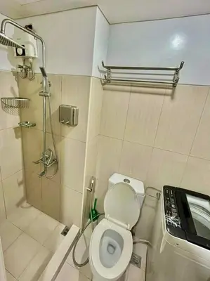 a bathroom with a toilet and a shower and a sink at MD staycation in Manila