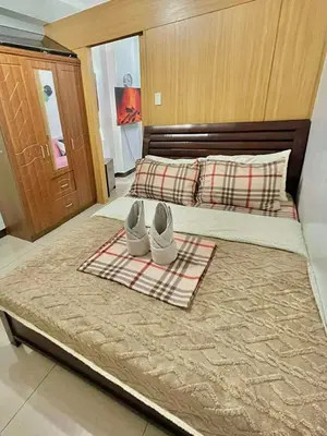 a bed with a pair of white shoes on it at MD staycation in Manila